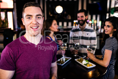 Portrait of man having a drink with friends