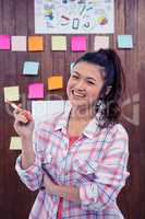 Smiling woman against wooden wall with notes on it