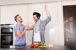 Smiling gay couple having fun while preparing food