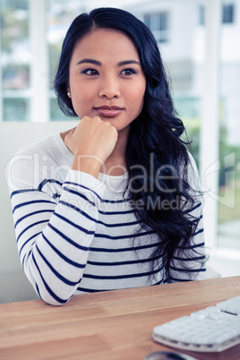 Attractive Asian woman with fist on chin posing for the camera