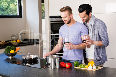 smiling gay couple preparing food