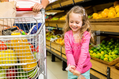 Little girl holding a bag of fruit