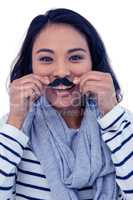 Pretty Asian woman with fake mustache posing for camera