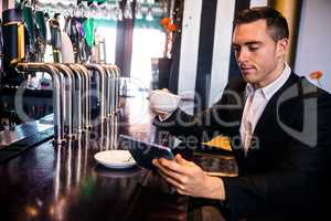 Businessman using tablet having a coffee