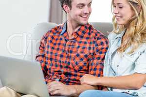 Couple using laptop on the couch