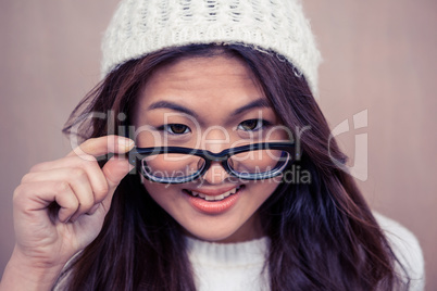 Smiling Asian woman holding eyeglasses