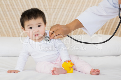 Cute baby being visited by doctor