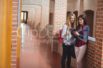 Smiling students using tablet together