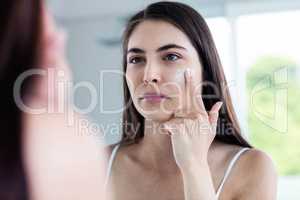Brunette applying face cream
