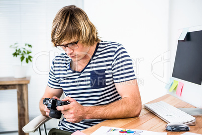 Focused hipster businessman checking photo on camera