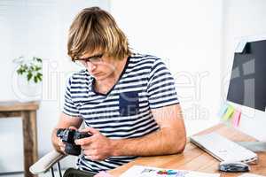 Focused hipster businessman checking photo on camera