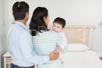 Family with baby daughter in bedroom