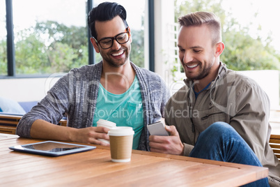 Designers with take-away coffee using smartphone