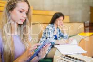 Pretty blonde student using tablet