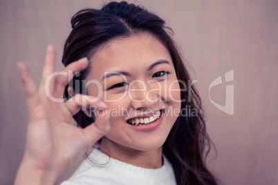Smiling woman making ok sign with hand