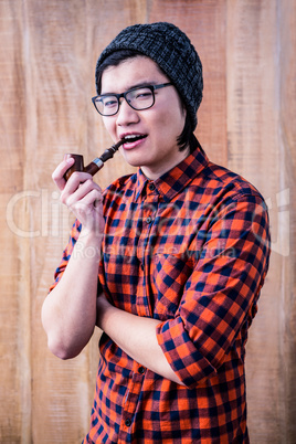 Hipster smoking pipe with crossed arms