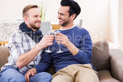 Gay couple toasting on the couch
