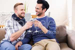 Gay couple toasting on the couch