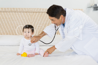 Cute baby being visited by doctor