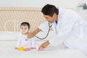 Cute baby being visited by doctor