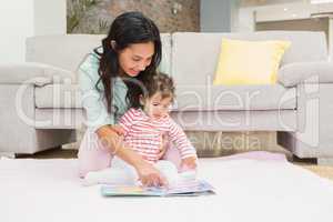 Happy mother with her baby looking at a book