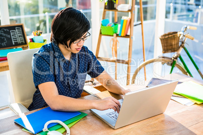 Smiling hipster businessman using laptop