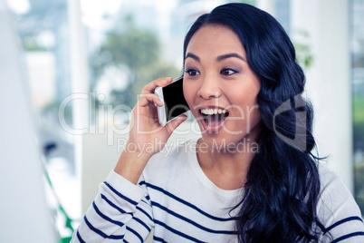 Surprised Asian woman on phone call
