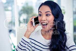 Surprised Asian woman on phone call