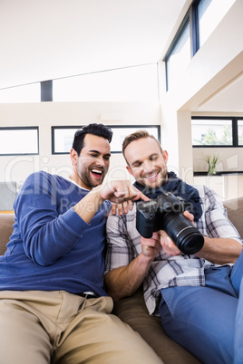 Gay couple watching pictures on the couch