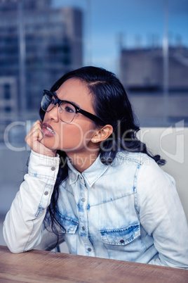 Troubled Asian woman with chin on fist