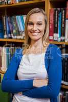 Smiling female student with arms crossed in the library