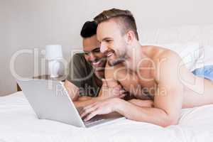 Smiling gay couple using laptop
