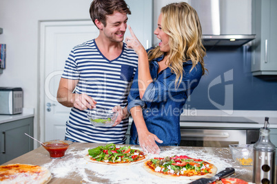 Smiling couple preparing pizza