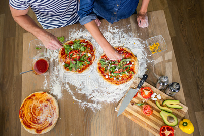 Smiling couple preparing pizza