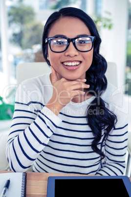 Smiling Asian woman with hand on chin looking at the camera