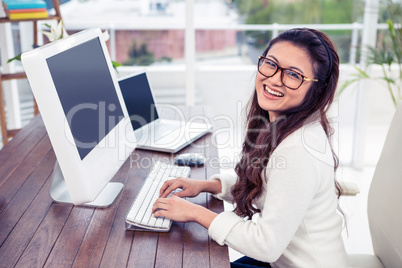 Smiling Asian woman working on computer