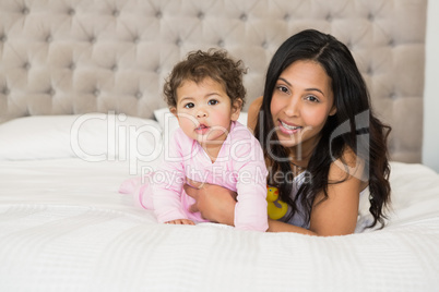 Brunette playing with her baby and a duck