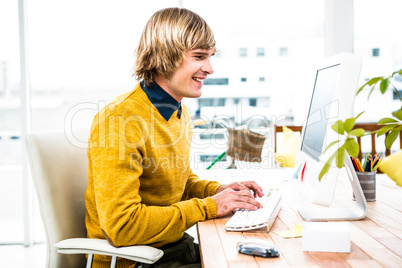 Smiling hipster businessman using his computer