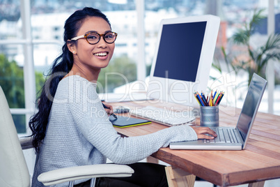 Smiling Asian woman using laptop and digital board