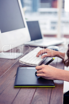 Feminine hands using digital board and computer keyboard