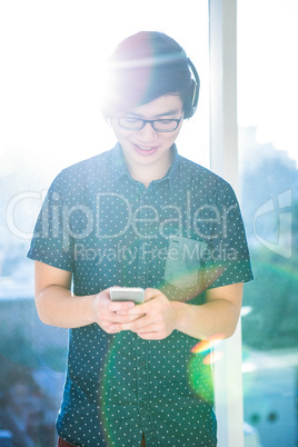 Smiling hipster businessman listening music