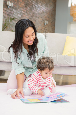 Happy mother with her baby looking at a book