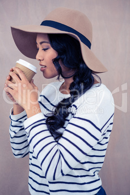 Attractive woman with hat holding disposable cup