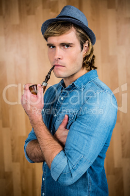 Serious hipster smoking pipe Serious hipster smoking pipe