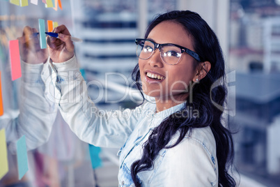 Asian woman writing on sticky notes
