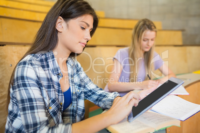Pretty brunette student using tablet