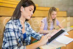 Pretty brunette student using tablet