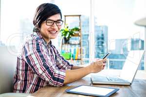 Smiling hipster businessman using smartphone