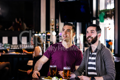 Friends having a pint and watching tv