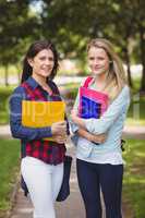 Smiling students holding binder